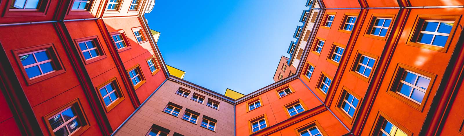 Looking up at colourful buildings and a blue sky