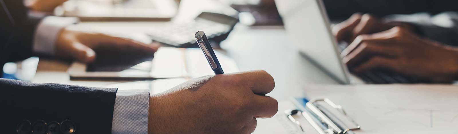 People at work, close up view of hands, writing and typing on a desk