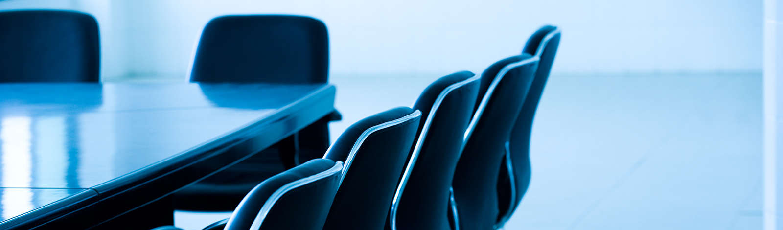 A board room with empty chairs, all in blue