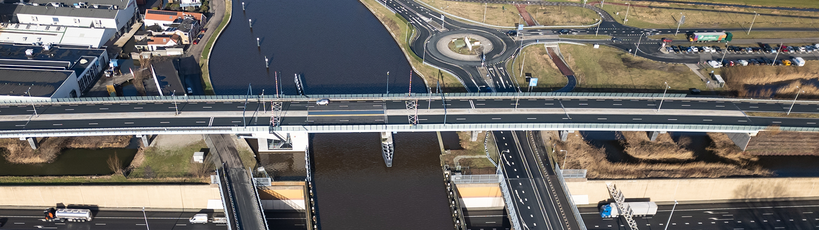 A waterway with a bridge crossing it, and roads on the banks of a river